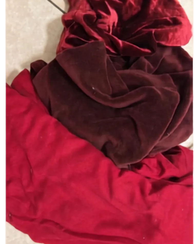 Surplus velvet and curtain fabric, folded on the floor