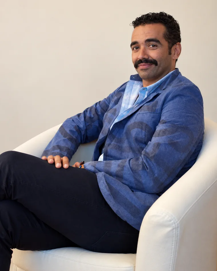 Moises Nascimento wearing a blazer made from street signage