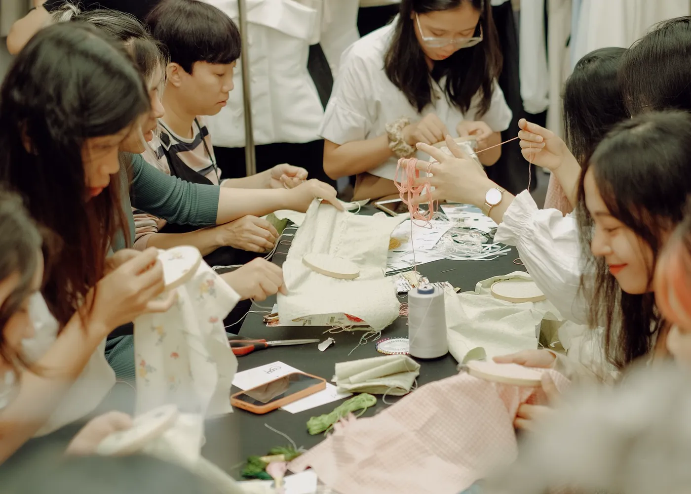 People sewing together around a table